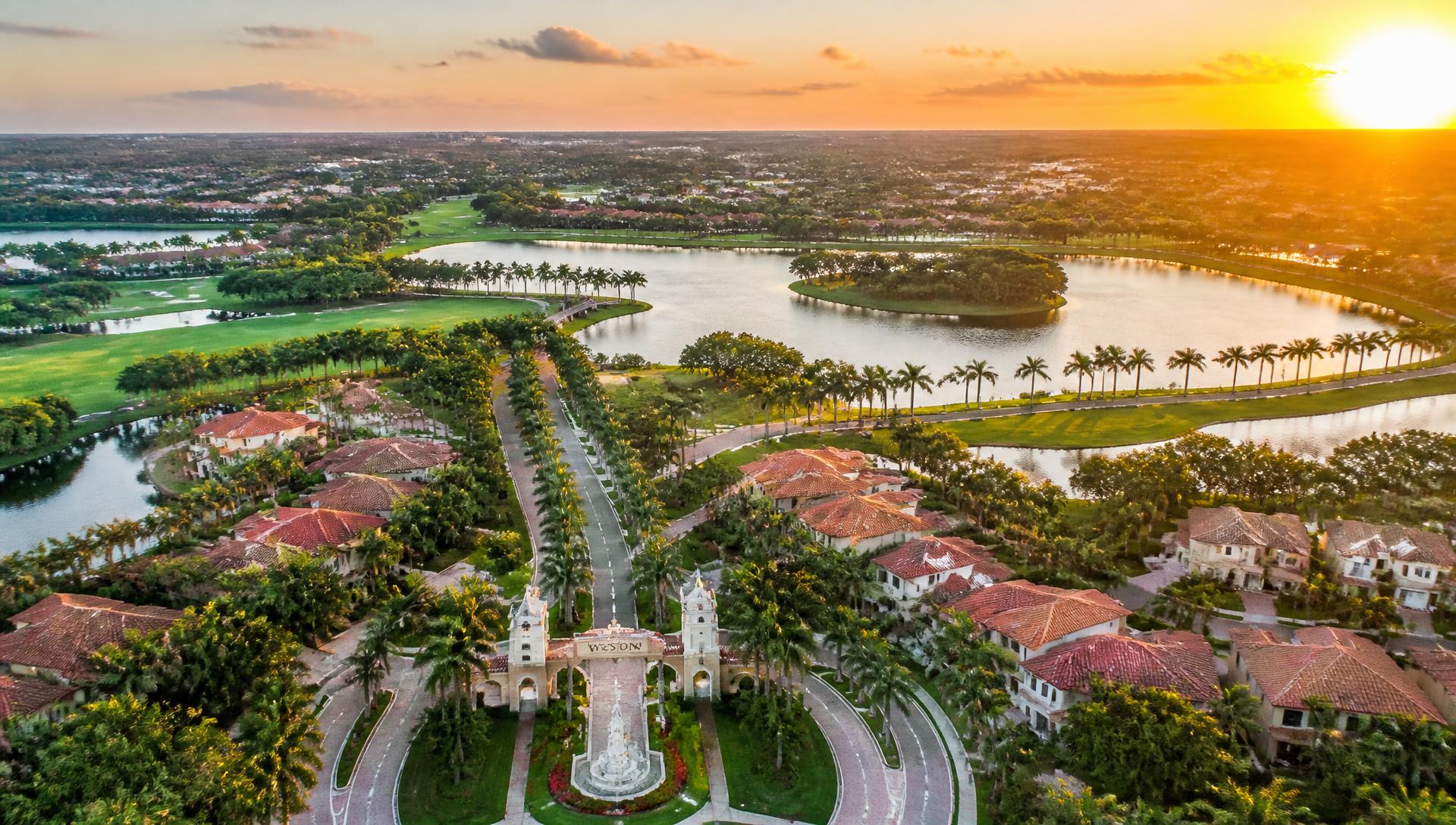 Aerial view of Weston, Florida lakes, parks and tile-roof homes at golden hour